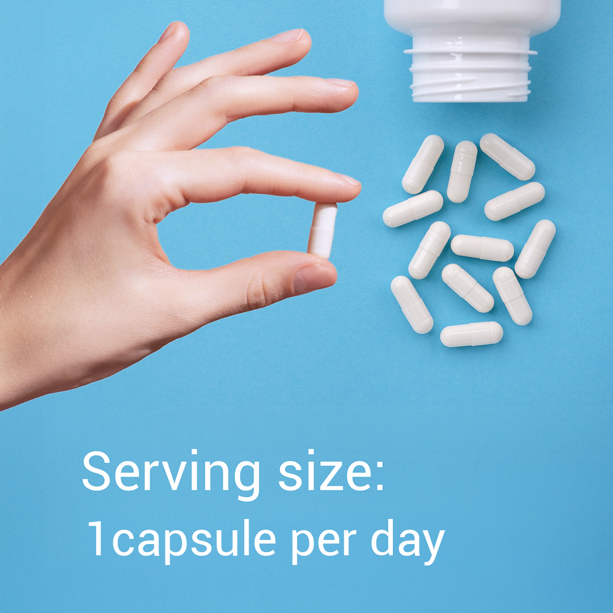 Hand holding a white capsule with text about serving size on a blue background