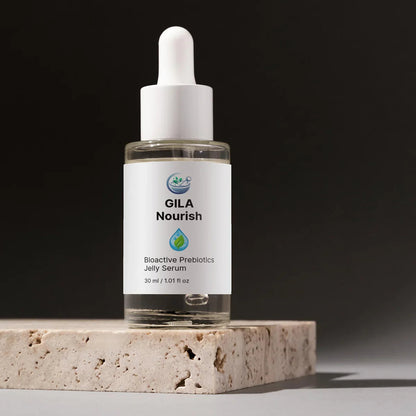 Bottle of GILA Nourish Bioactive Prebiotics Jelly Serum on a stone surface with a dark background