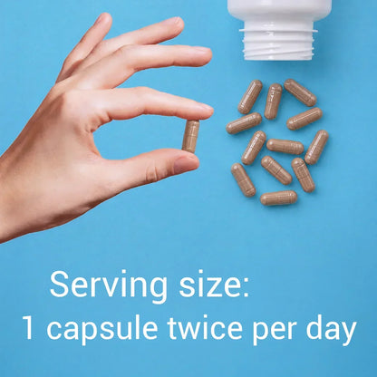 Hand holding a capsule with text about serving size on a blue background