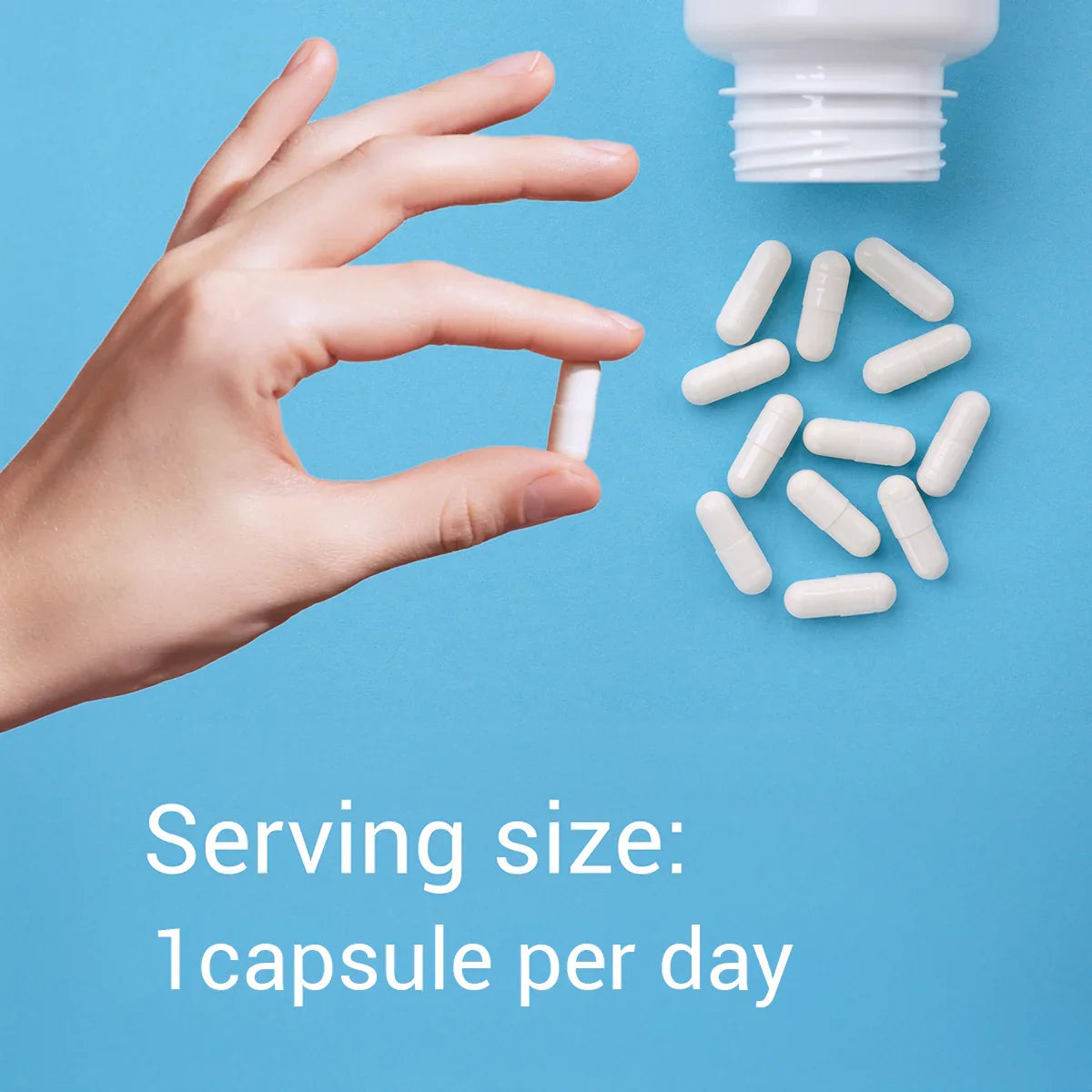 Hand holding a white capsule with text about serving size on a blue background