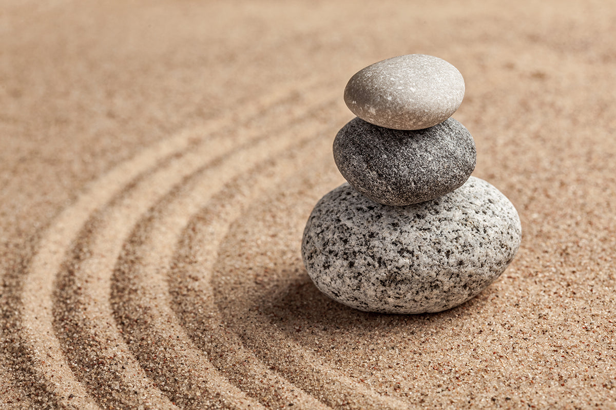 Stack of stones on sand with concentric circles