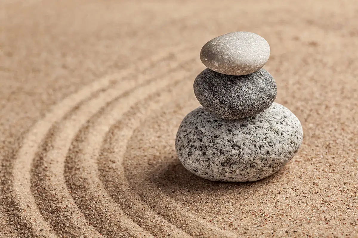 Stack of stones on sand with concentric circles